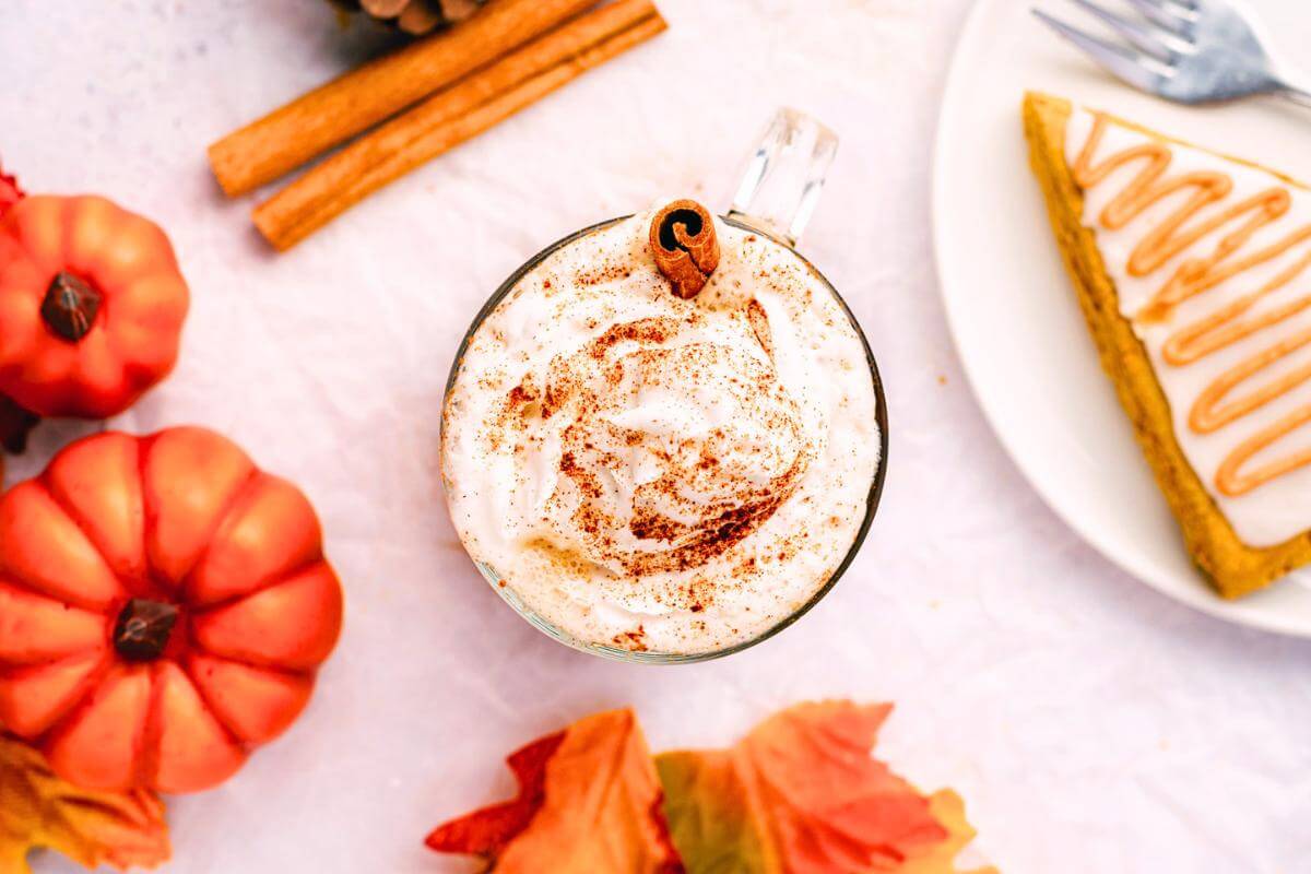 A pumpkin spice latte in a glass with whipped cream.