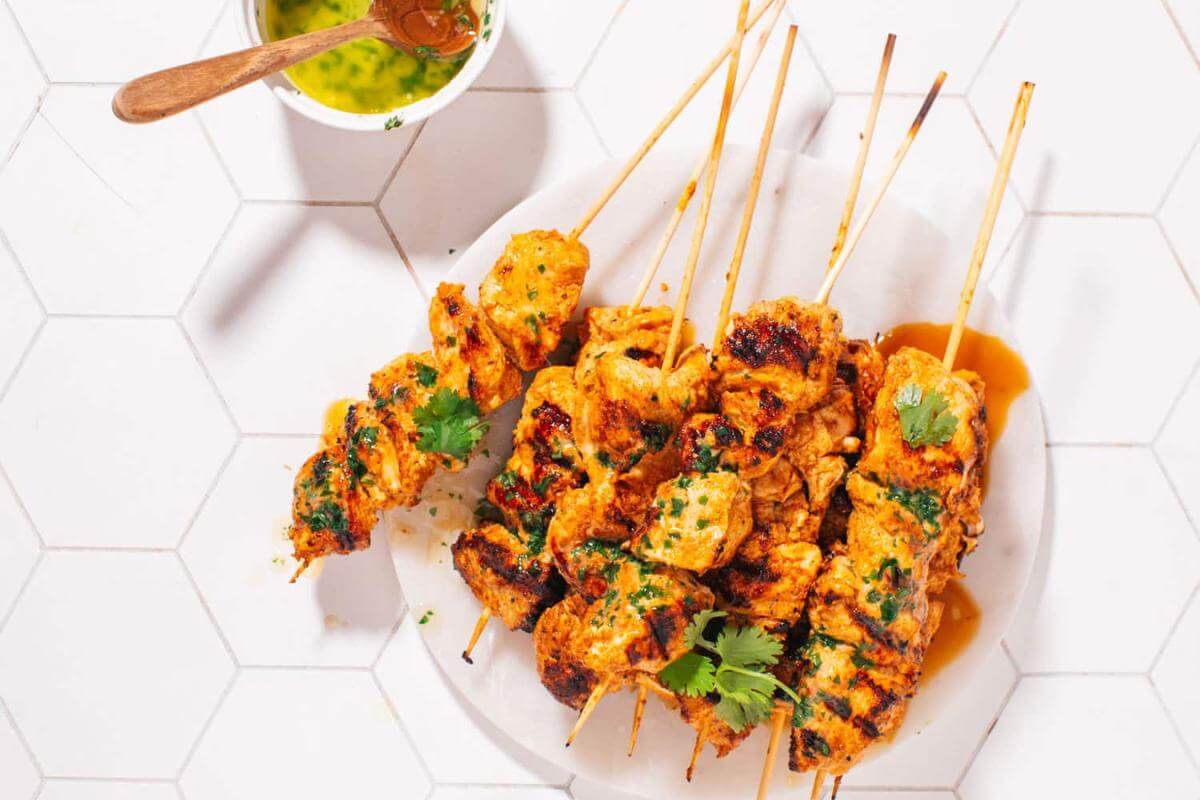 Chicken tikka skewers on a plate.