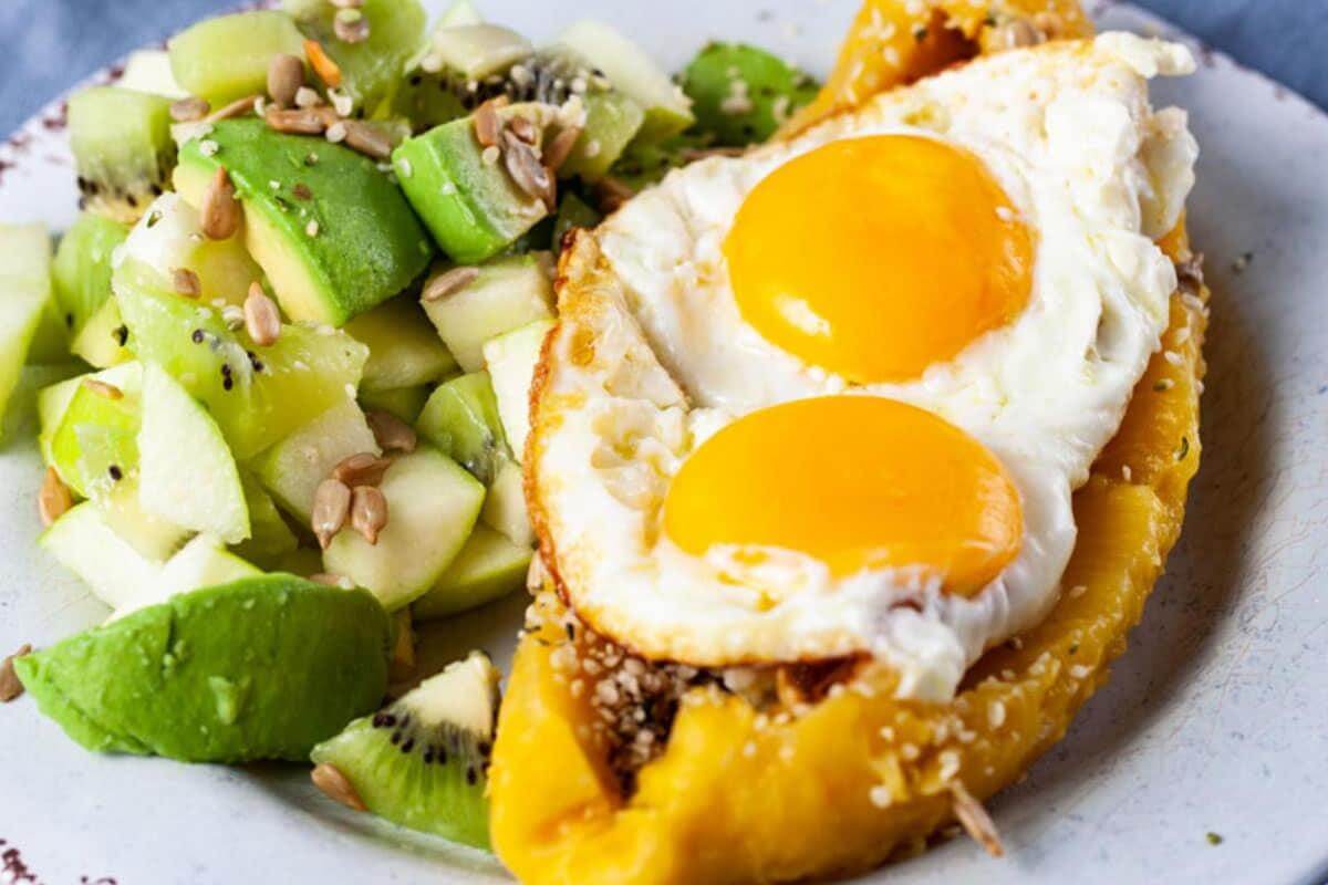 A plantain with eggs on top and veggies on the side.