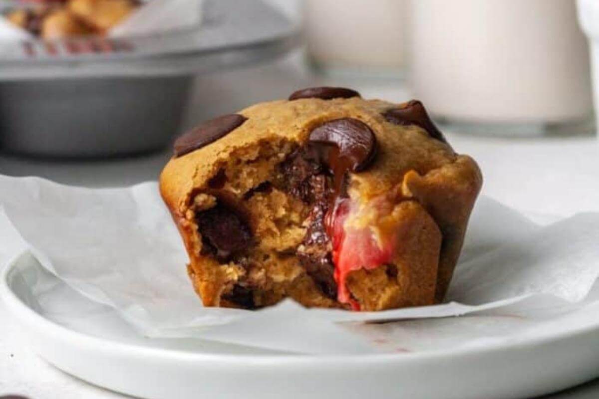 A chocolate strawberry muffin on a plate.