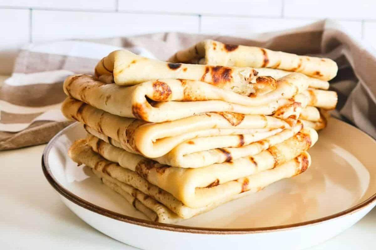 A stack of crepes on a plate.