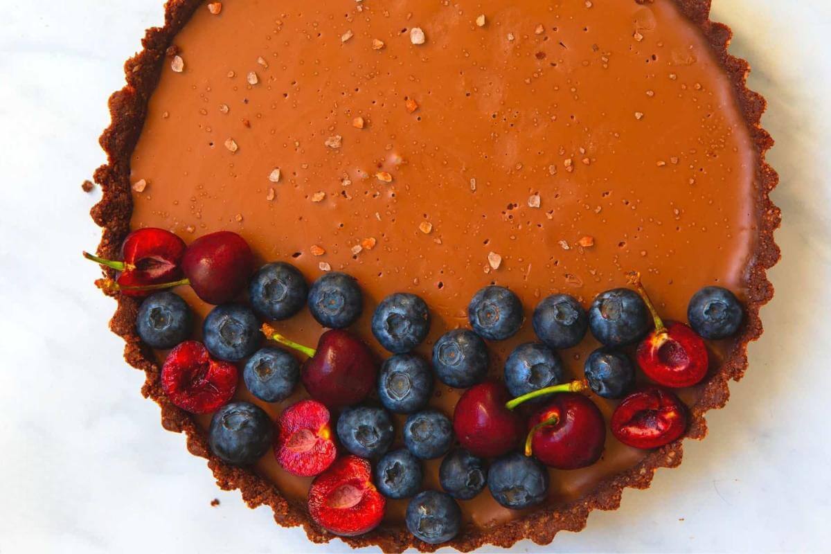 A vegan chocolate tart with fresh berries.