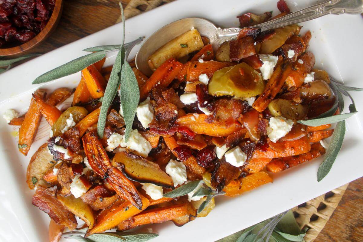 Roasted carrots and apples in a dish.