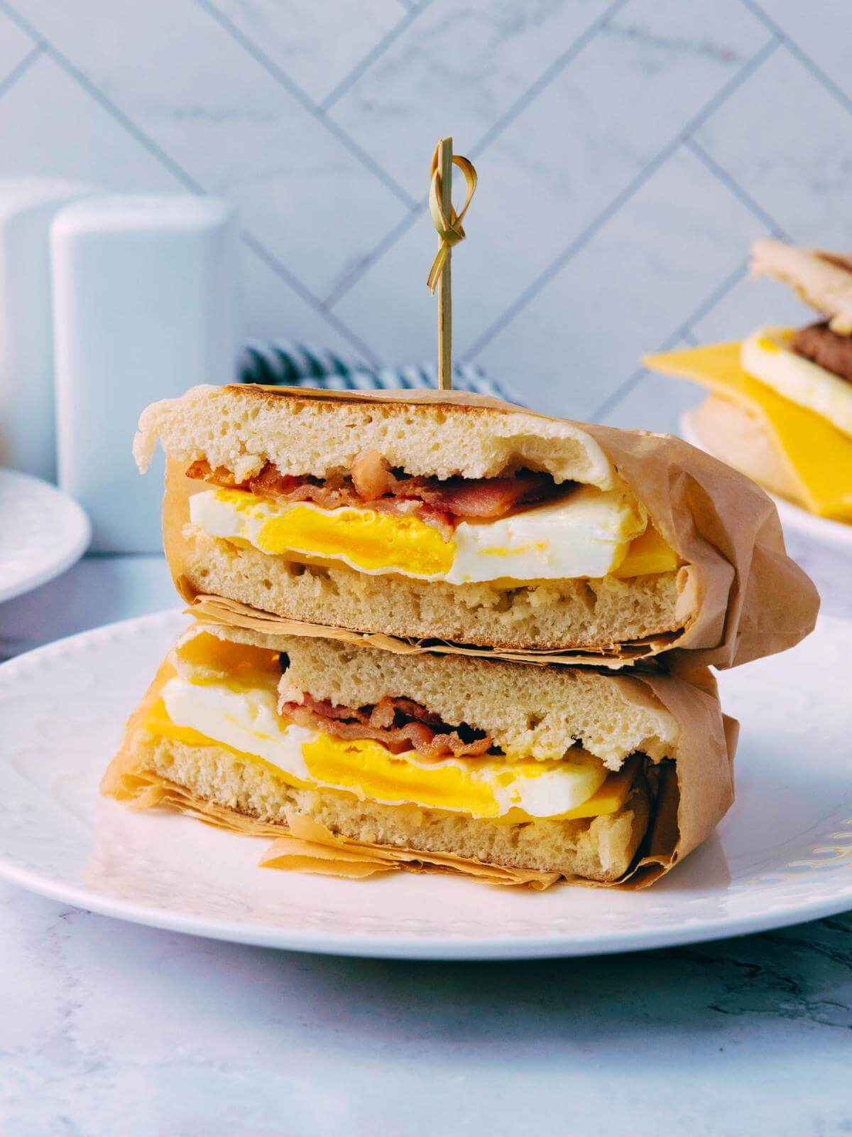 A cut breakfast sandwich on a plate.