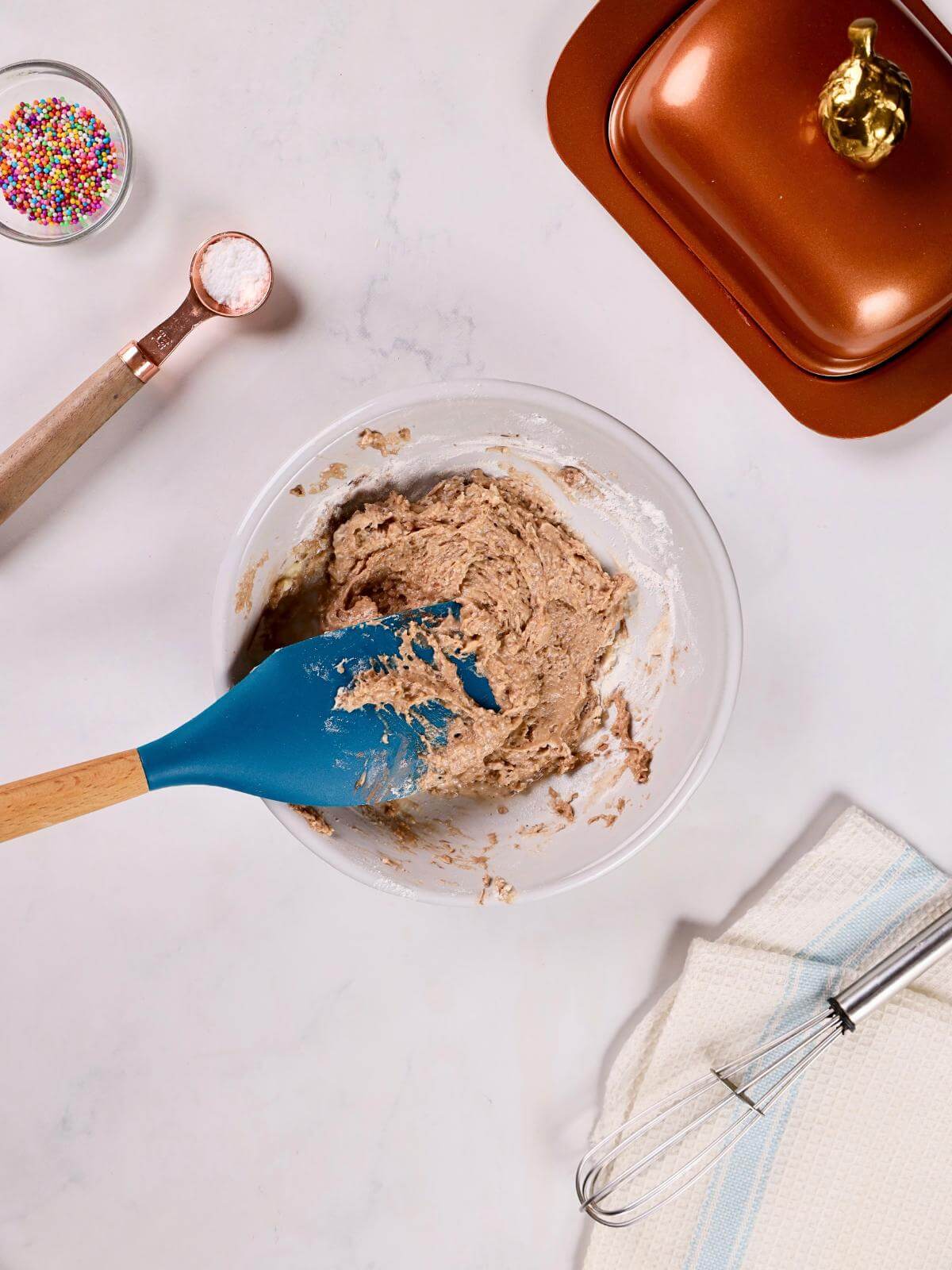 Ingredients for making red velvet cake pops being mixed in a bowl.