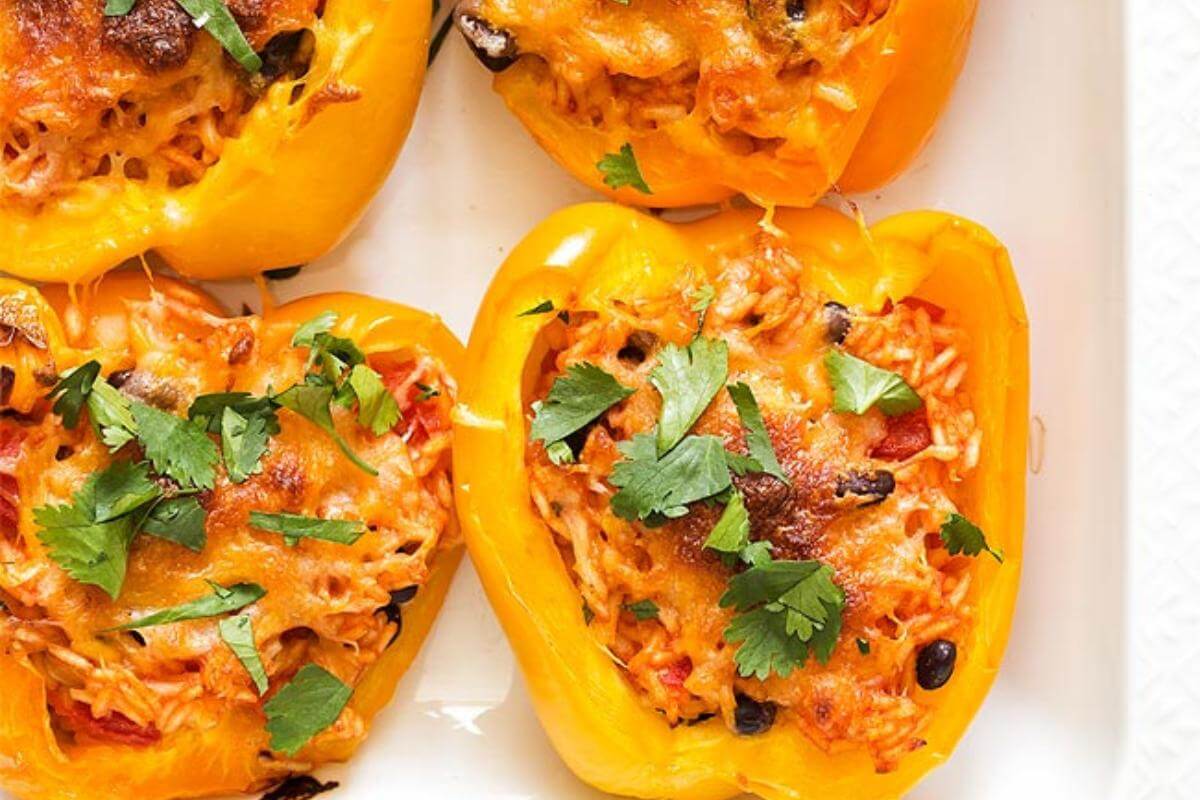 Stuffed yellow peppers in a dish.