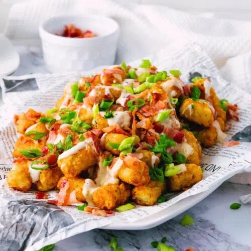 Loaded tater tots on newspaper.