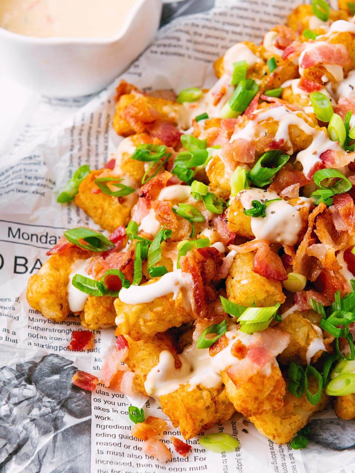 Loaded tater tots on newspaper.