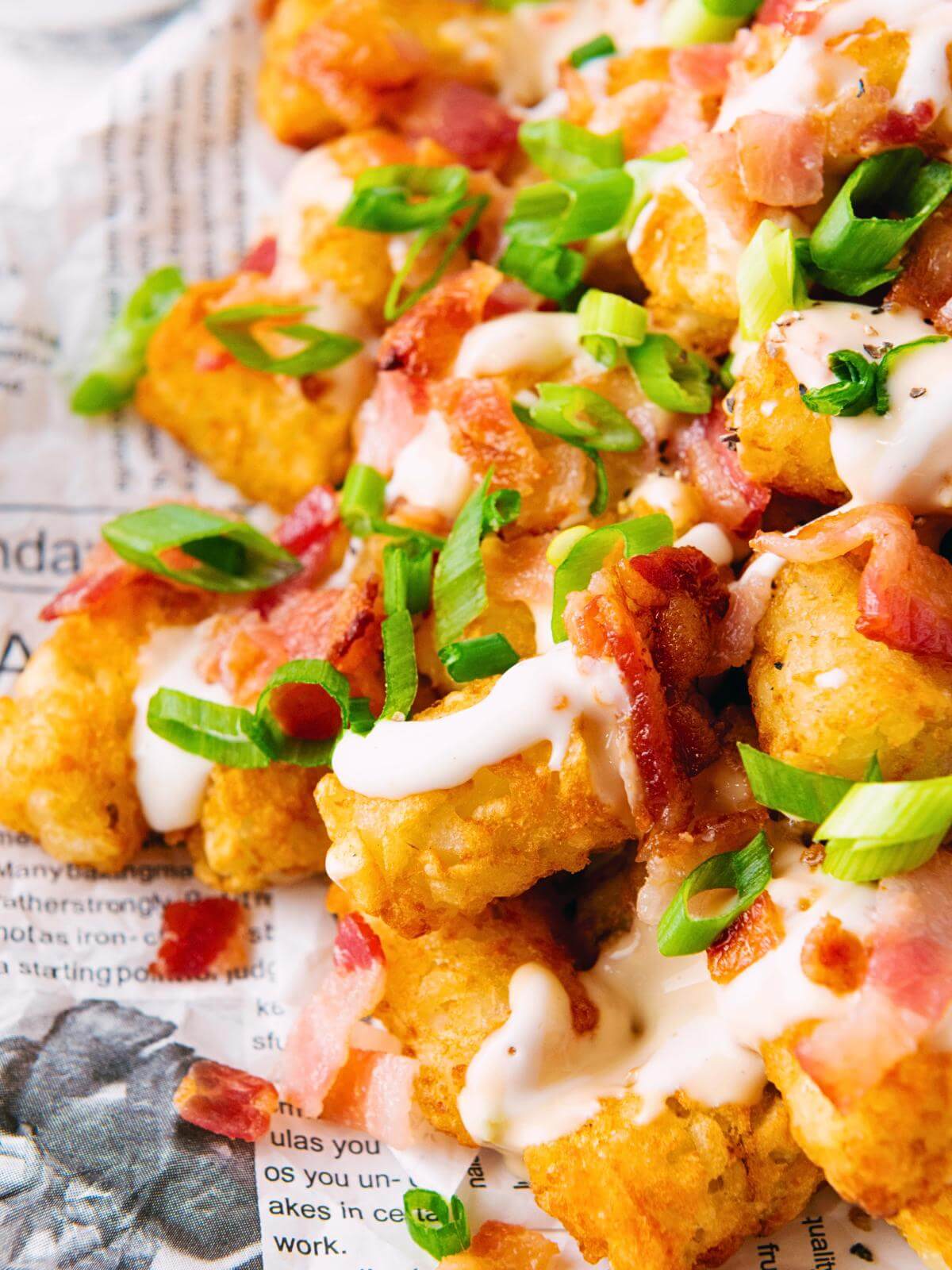 Loaded tater tots on newspaper.