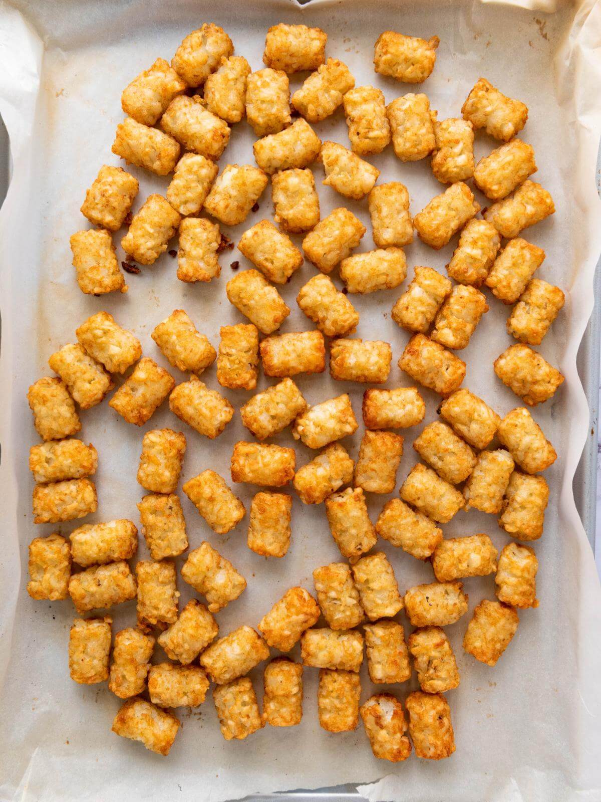 Baked tater tots on a baking sheet.