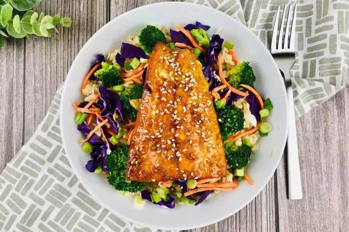 Teriyaki salmon on a plate with veggies.