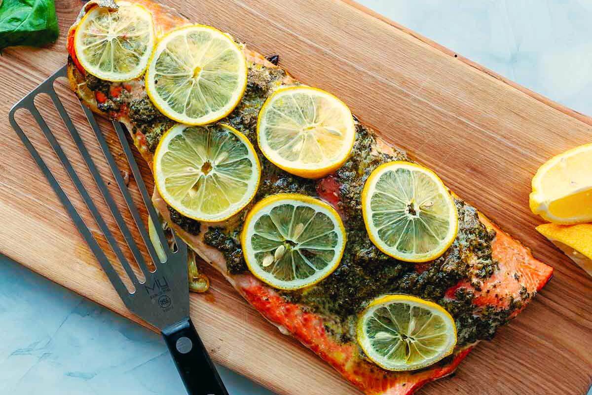 Salmon with pesto and lemon slices.