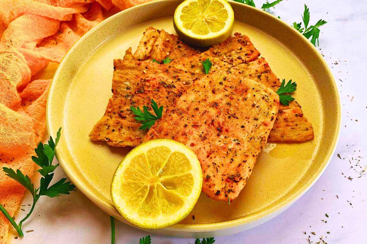 Cooked haddock and lemon slices on a plate.