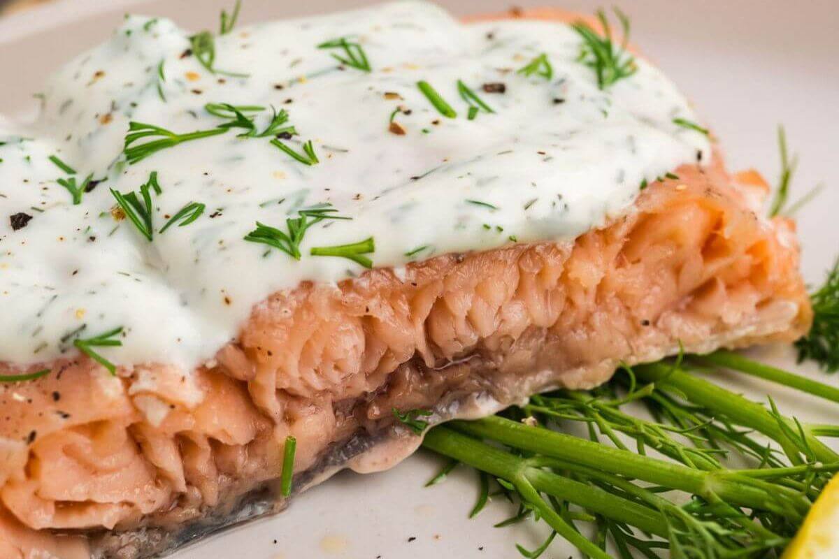 Cooked salmon with dill sauce.