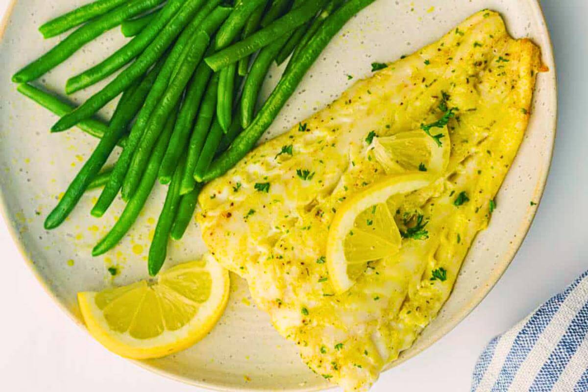 Air fryer cod and green beans on a plate.