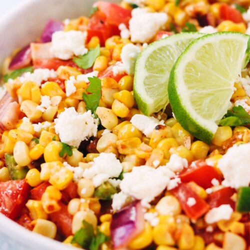 Mexican street corn and tomato salad in a bowl.