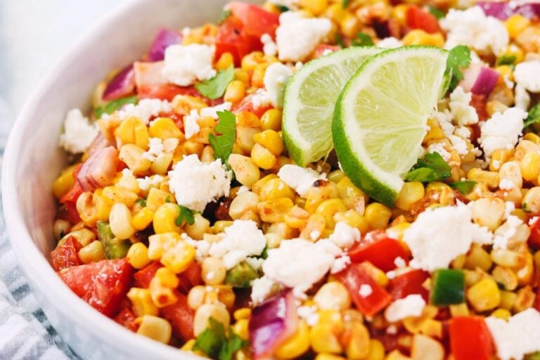 Mexican street corn and tomato salad in a bowl.