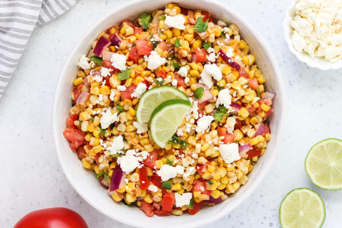 Mexican street corn and tomato salad in a bowl.