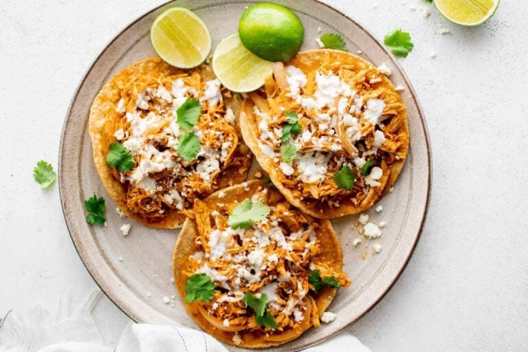 Shredded chicken tacos on a plate.