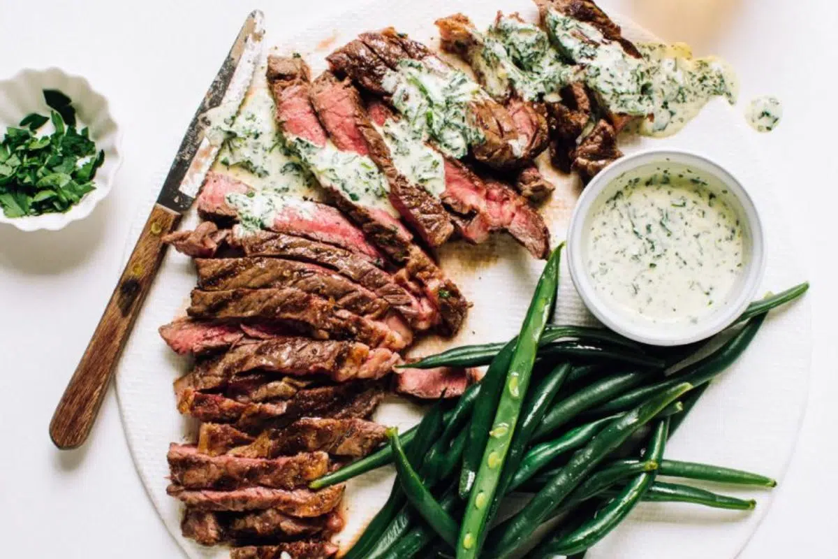 Flat iron steak with sauce and green beans.