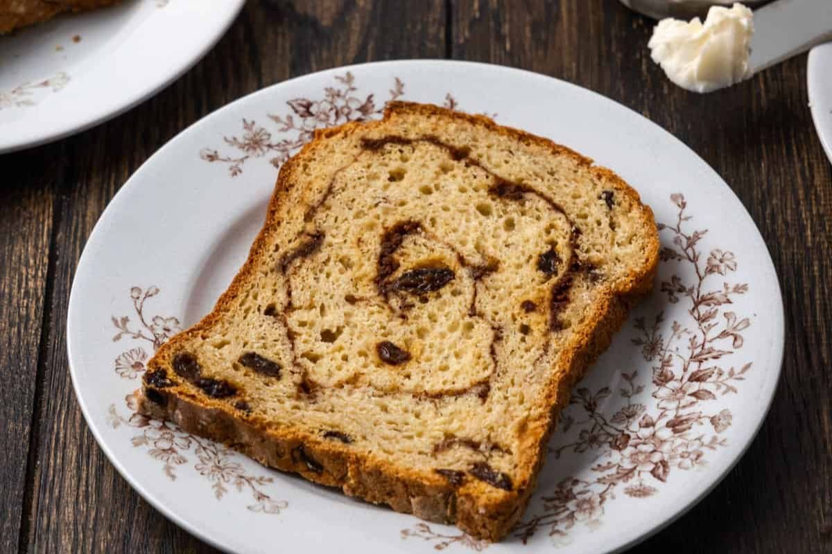 A slice of Gluten Free Cinnamon Raisin Bread on a plate.