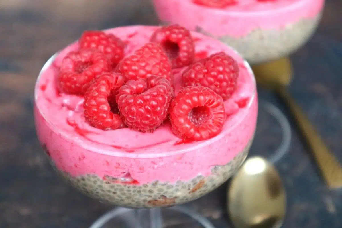 Close up look of overnight chia pudding with almond butter and raspberry coconut cream.