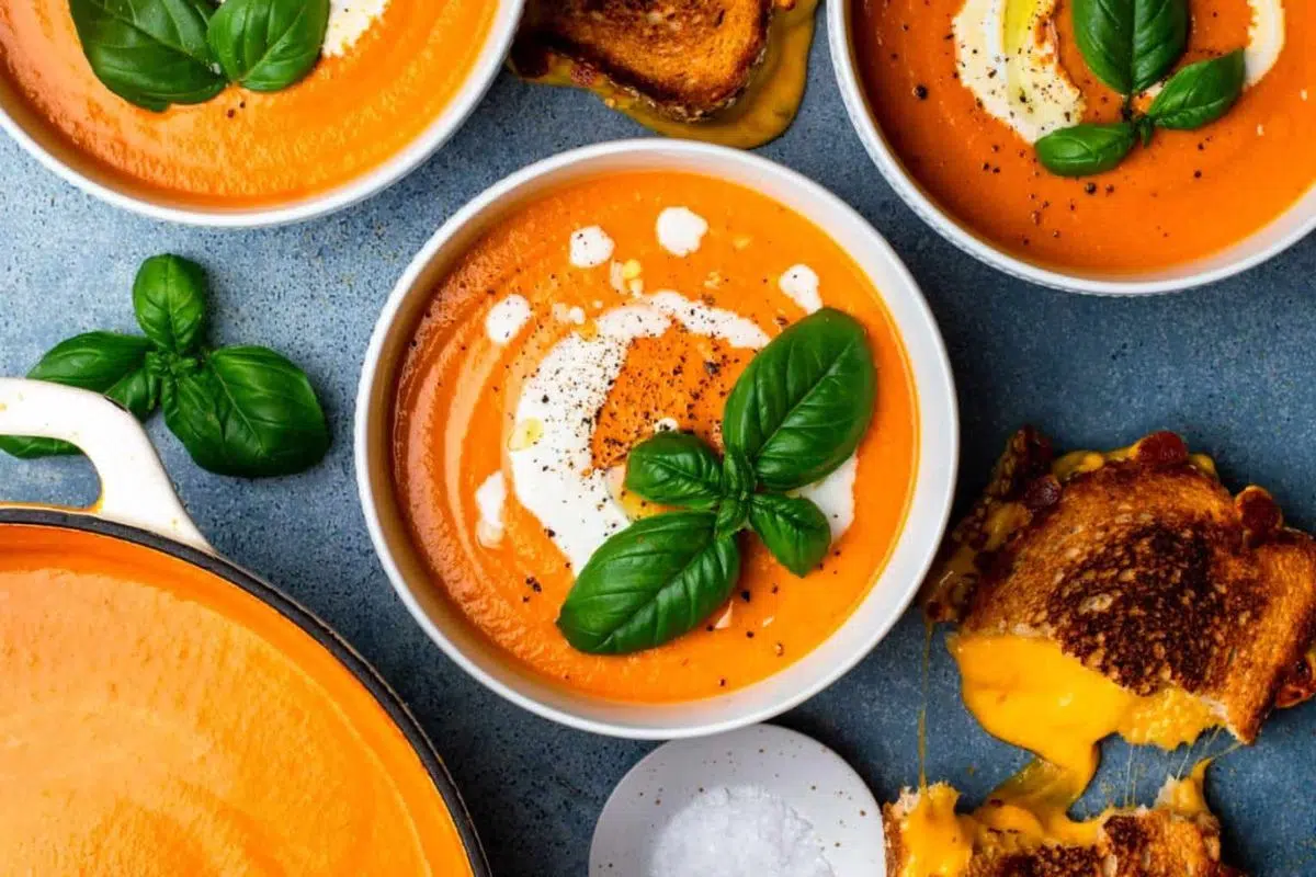 Simple Pumpkin Tomato Soup alongside provolone grilled cheese .