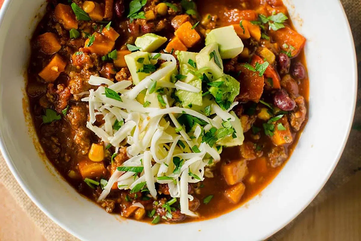 A bowl of chili with toppings.