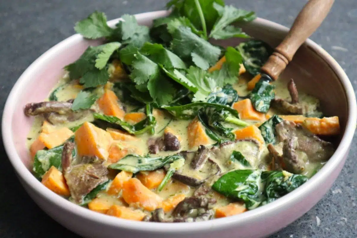 Vegan and soyfree Thai green curry topped with green leaves.