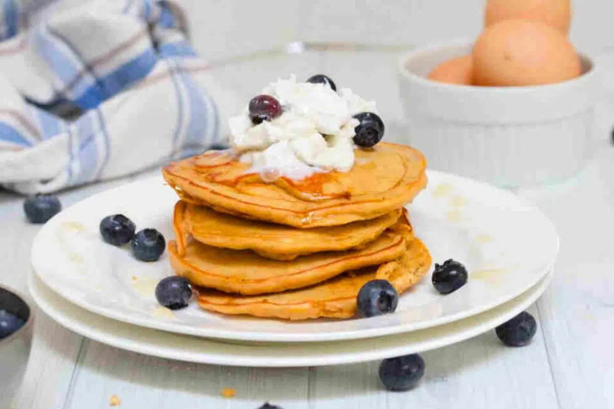 Protein Pancakes topped with whole30 whipped cream and blueberries.