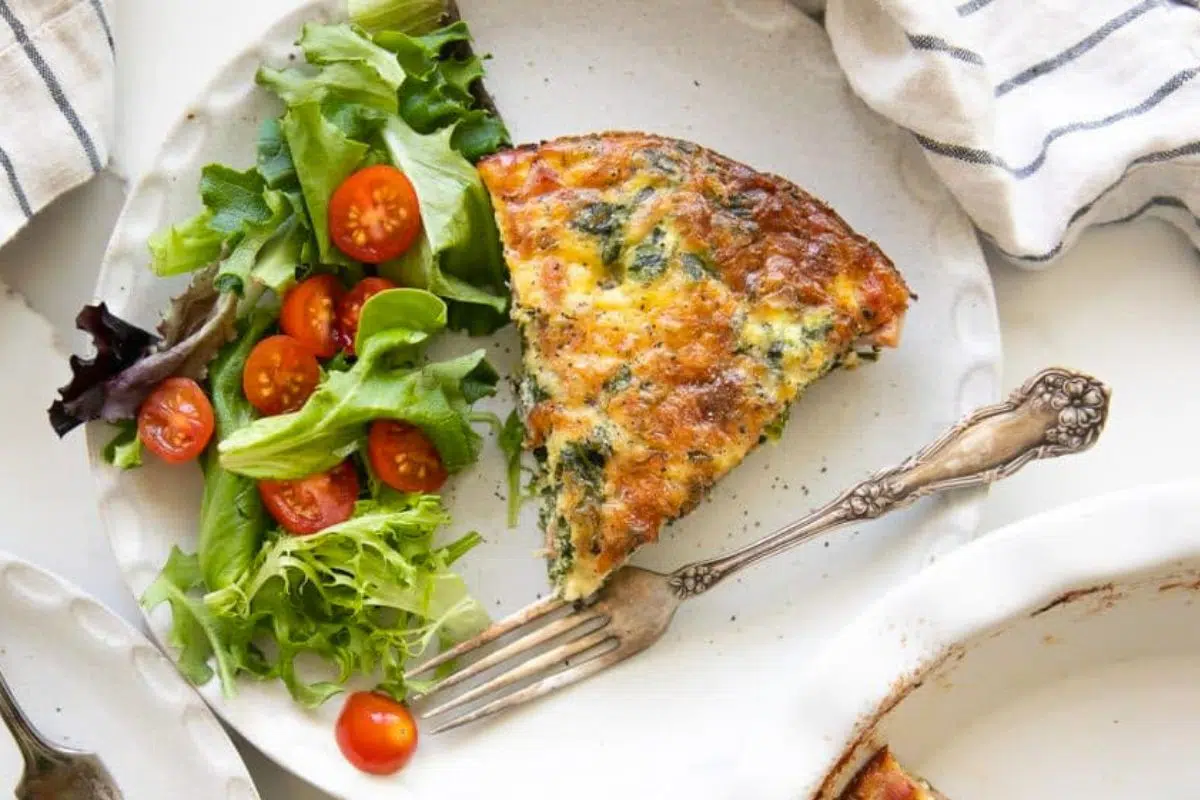A slice of Crustless Spinach Quiche served on a plate.