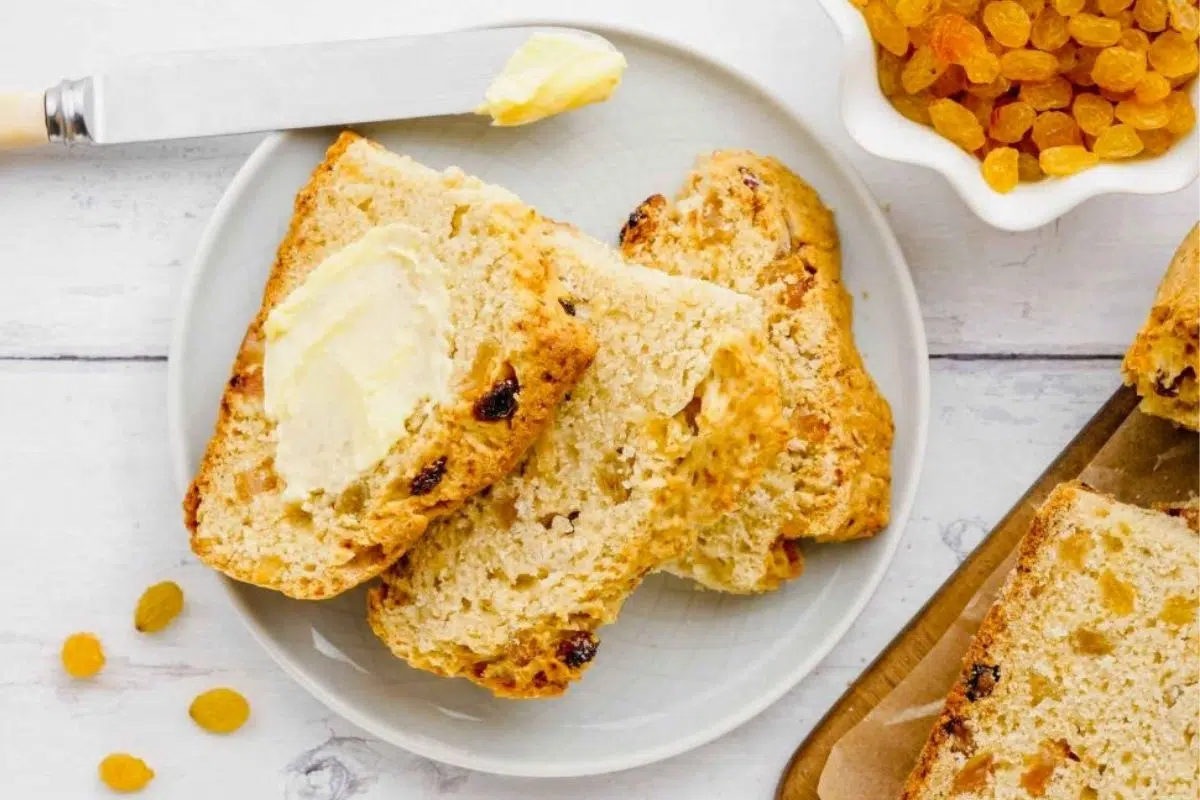 A slice of Soda Bread spread with butter.