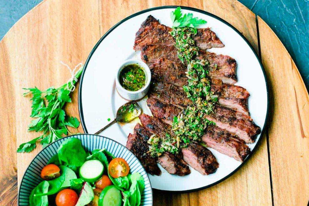 Grilled Skirt Steak with Chimichurri Sauce served on a plate.