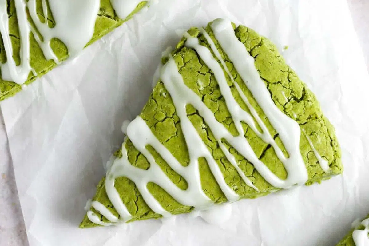 A slice of Matcha Scones drizzled with glaze.