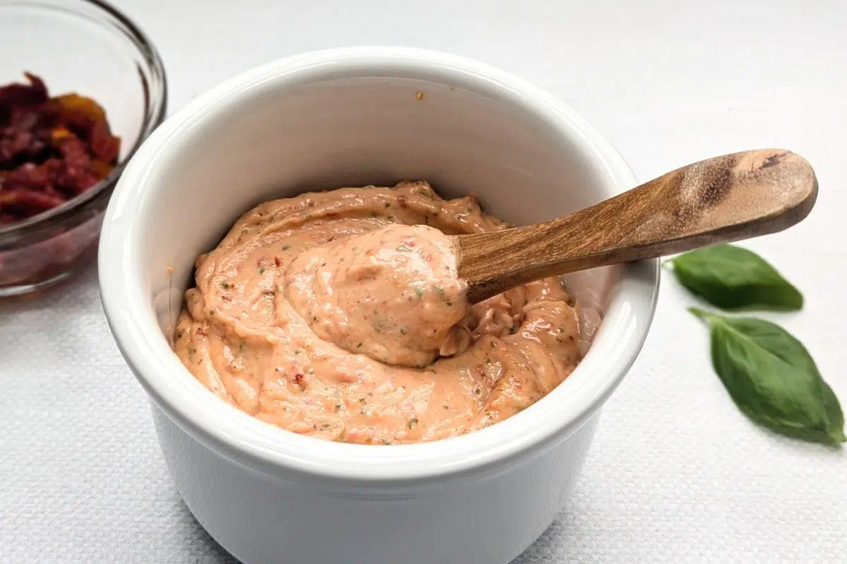Roasted Garlic Sun-Dried Tomato Aioli with basil leaves.