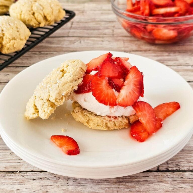 Gluten free strawberry shortcake with strawberries and whipped cream on a plate.
