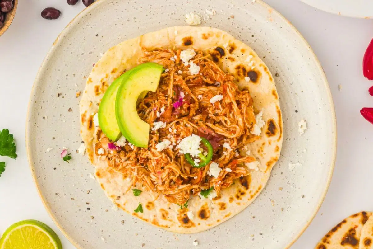 3-Ingredient Slow Cooker Salsa Chicken topped with avocado slices.