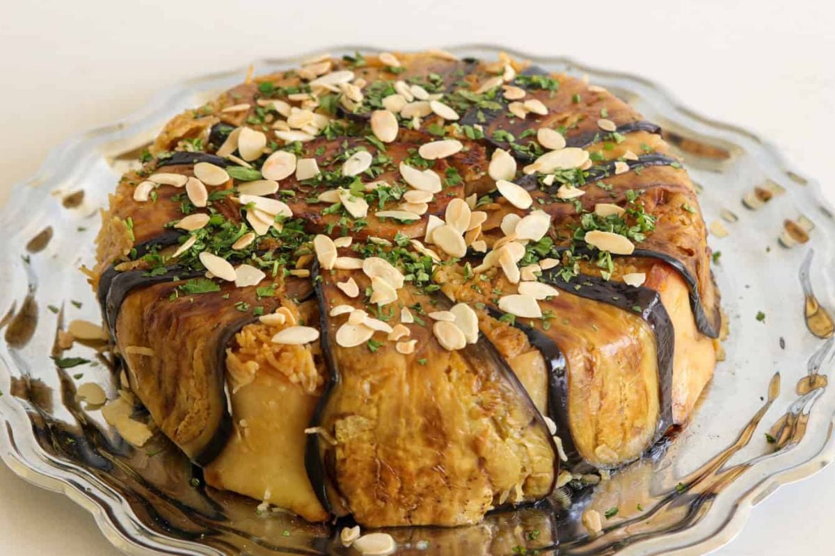 Chicken Maqluba topped with parsley and fried nuts.