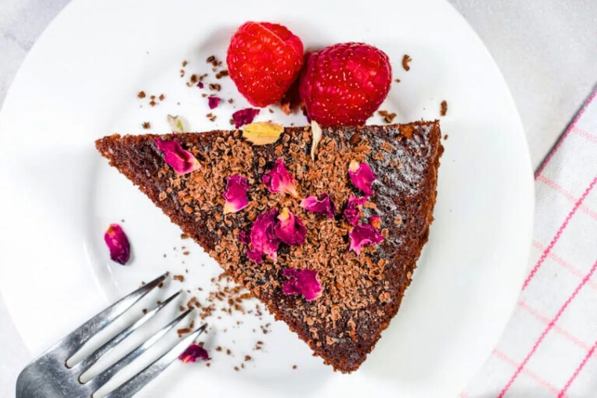 Chocolate Cake Recipe with Raspberry and Rose served on a plate.