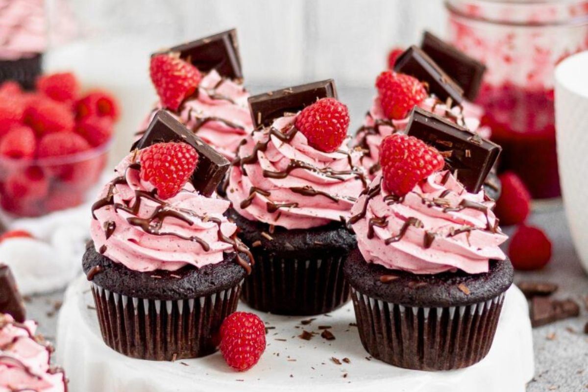 Chocolate Raspberry Cupcakes topped with fresh raspberries and chocolate bar pieces.