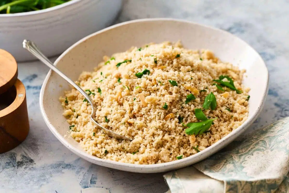 Fonio Pilaf with Toasted Almonds garnished with fresh herbs.