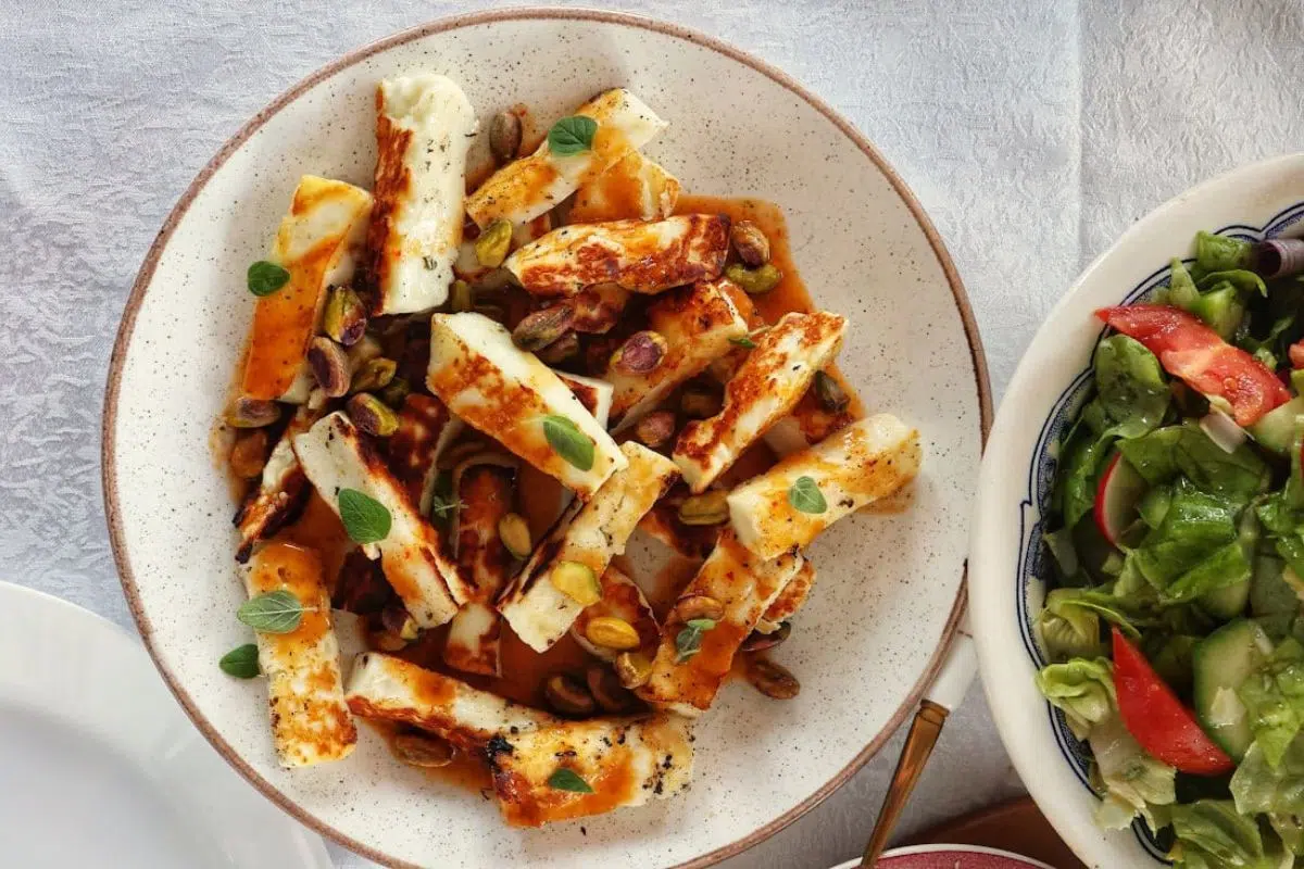 Grilled Halloumi with Orange Vinaigrette and Pistachios alongside fresh salad.