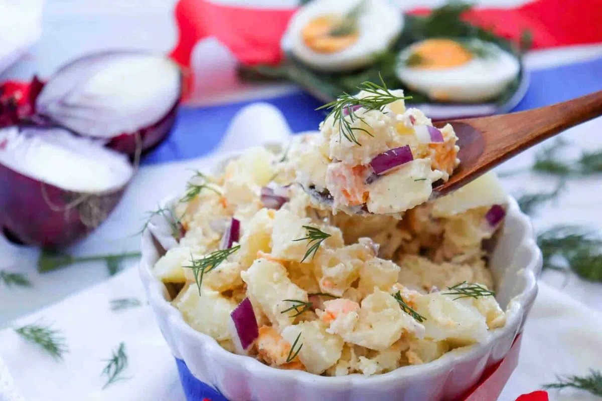 Homemade Potato Salad with Eggs garnished with chopped herb.