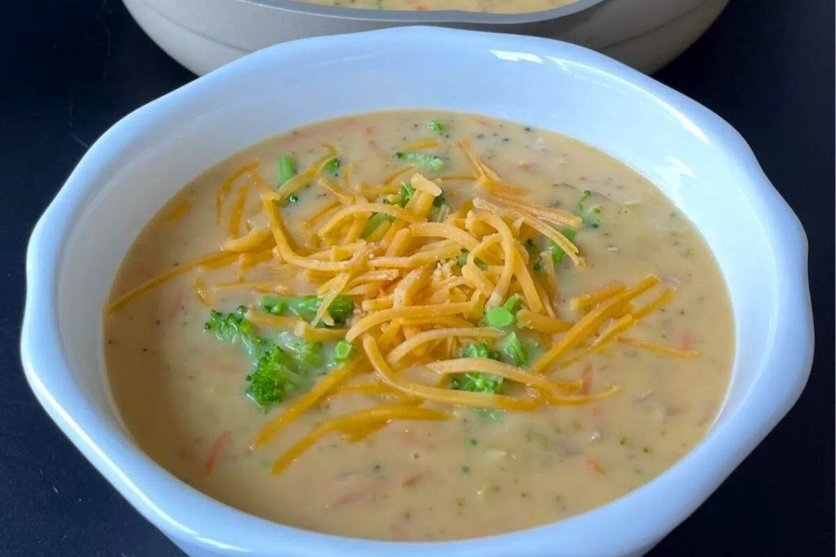 Keto Broccoli Cheddar Soup topped with shredded cheese.