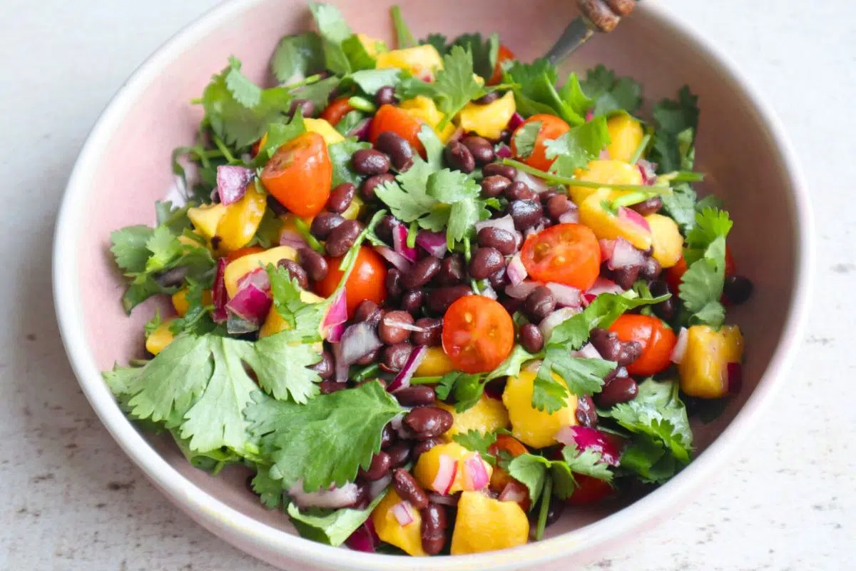 Mexican black bean salad with mango and cilantro served in a bowl.
