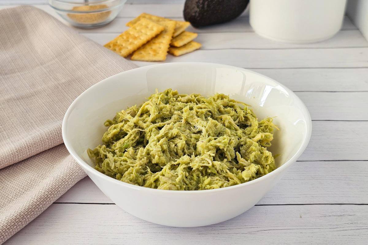 Avocado chicken salad in a white bowl.