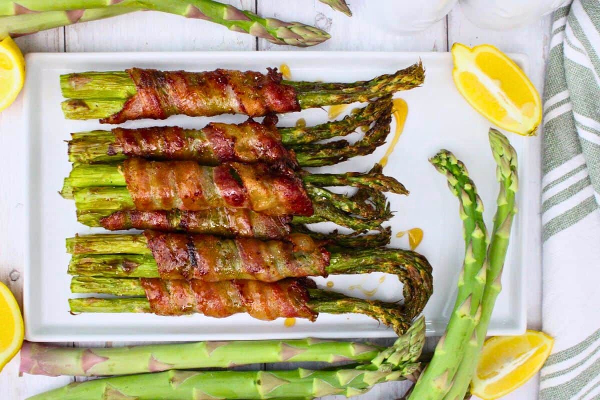 Air Fryer Bacon Wrapped Asparagus with lemon slices.
