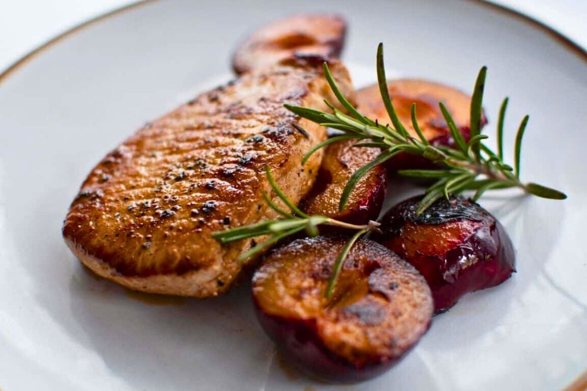 Pan-Fried Pork Chops with Plums and Rosemary served on a plate.