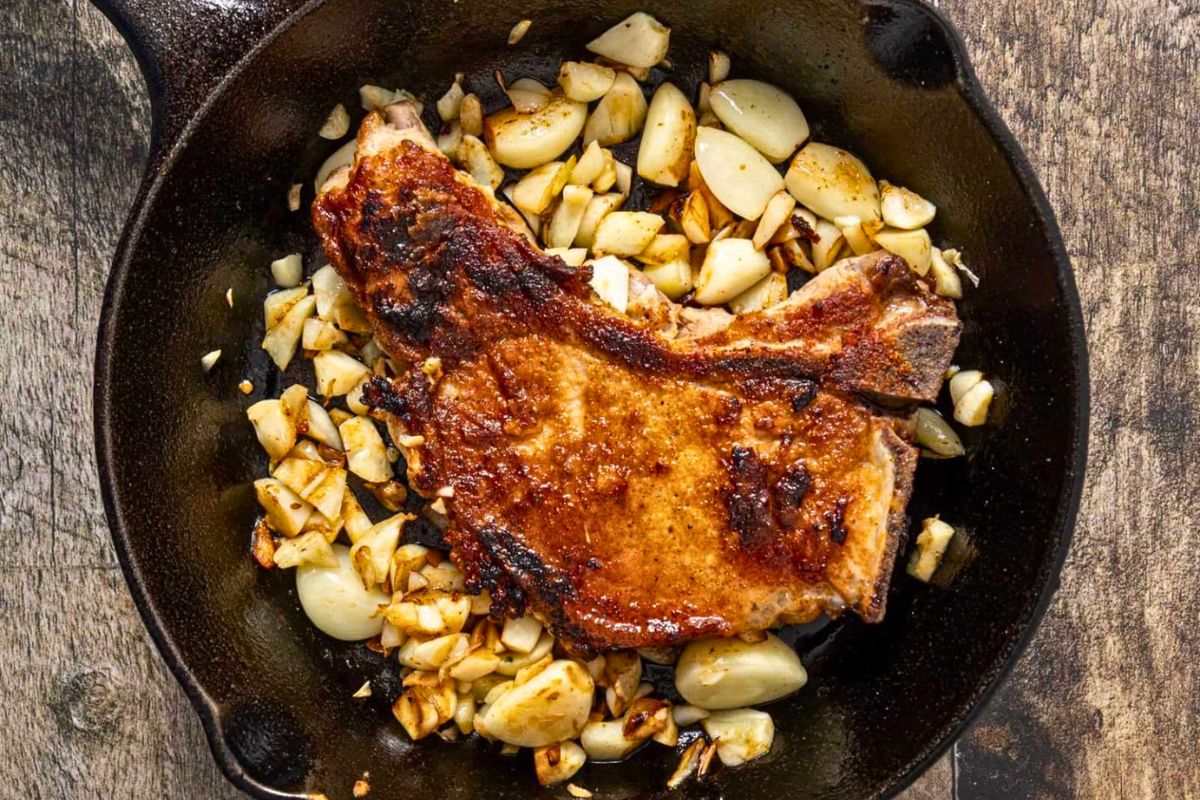 Seared Garlic Pork Chops in a skillet.