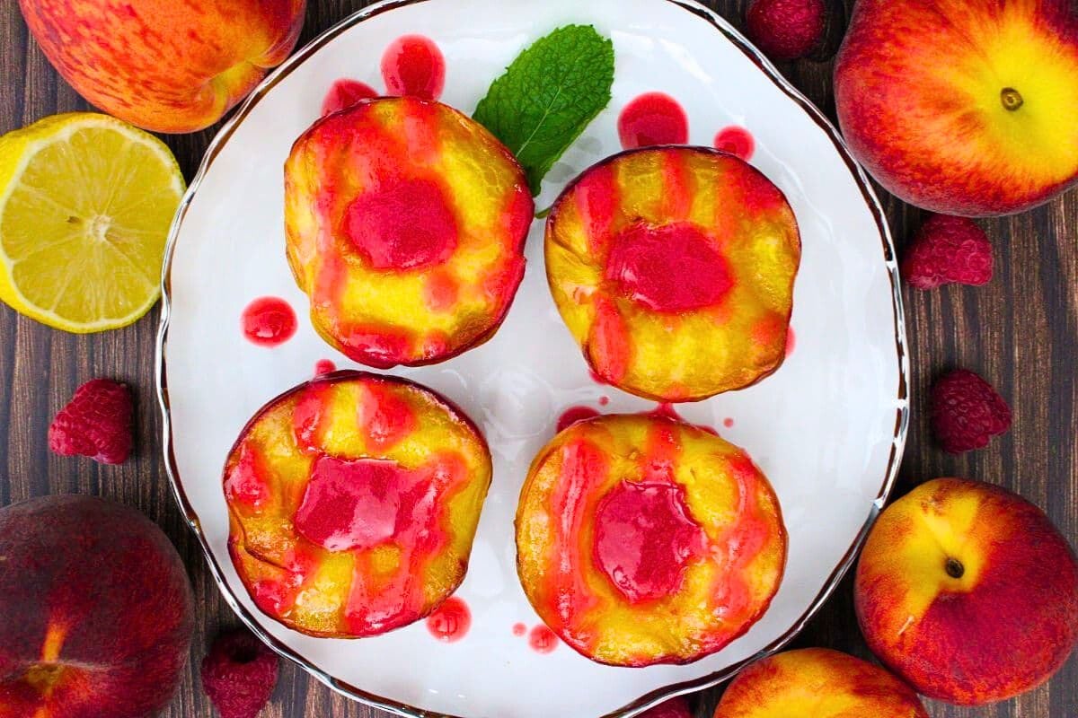 Air Fryer Grilled Peaches With Raspberry Melba Sauce in a plate with many apple surrounded in it. 